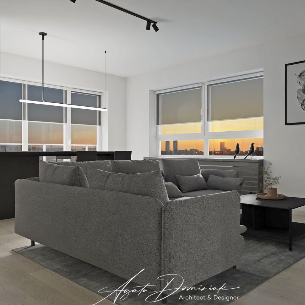 Salon z dużą szarą sofą i wyspą kuchenną z okapem tubą
