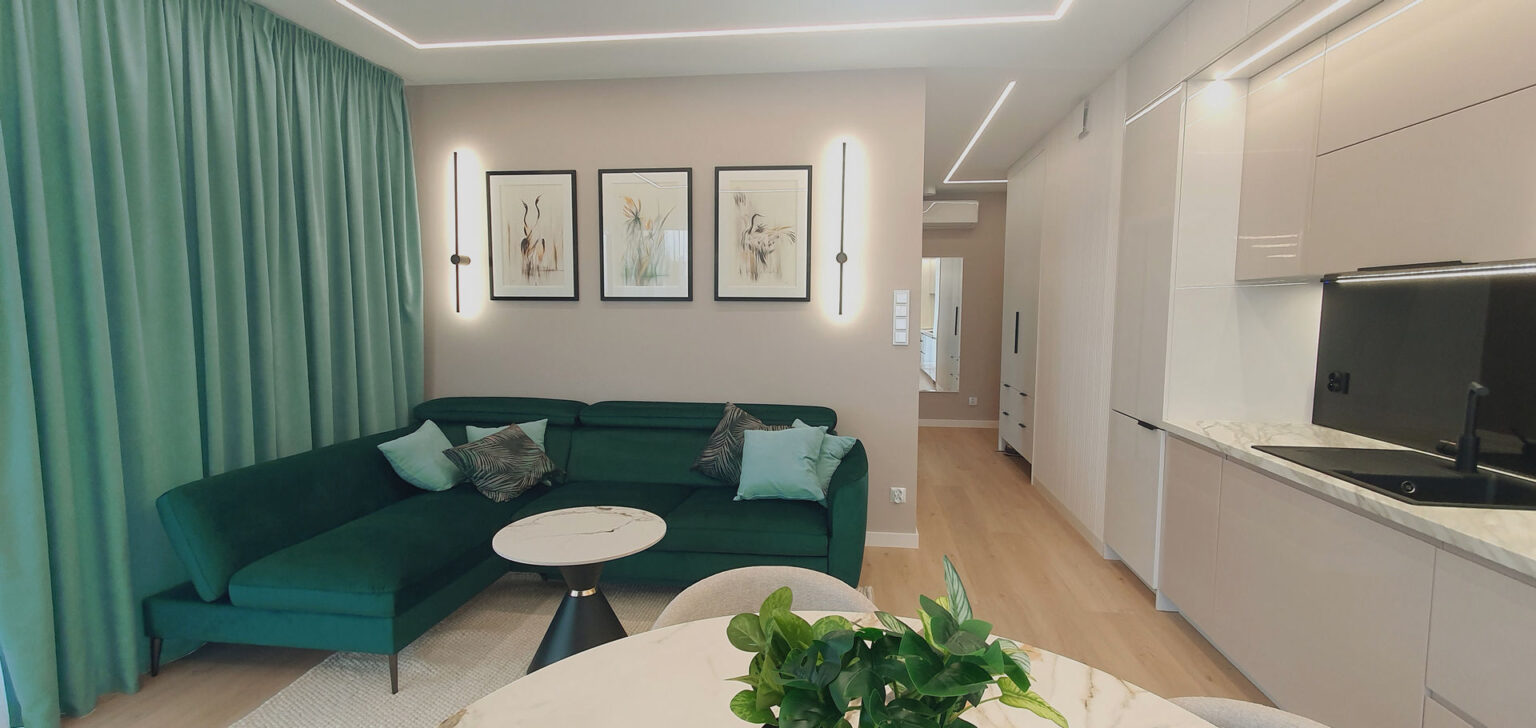 Salon z narożnikiem w butelkowej zieleni, stół z marmurowym blatem