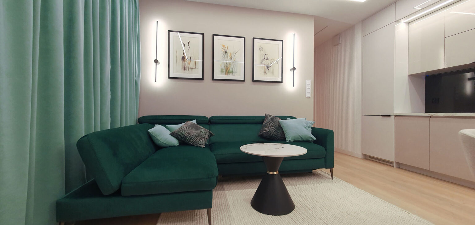 Sofa narożna w butelkowej zieleni, stolik kawowy z marmurowym blatem