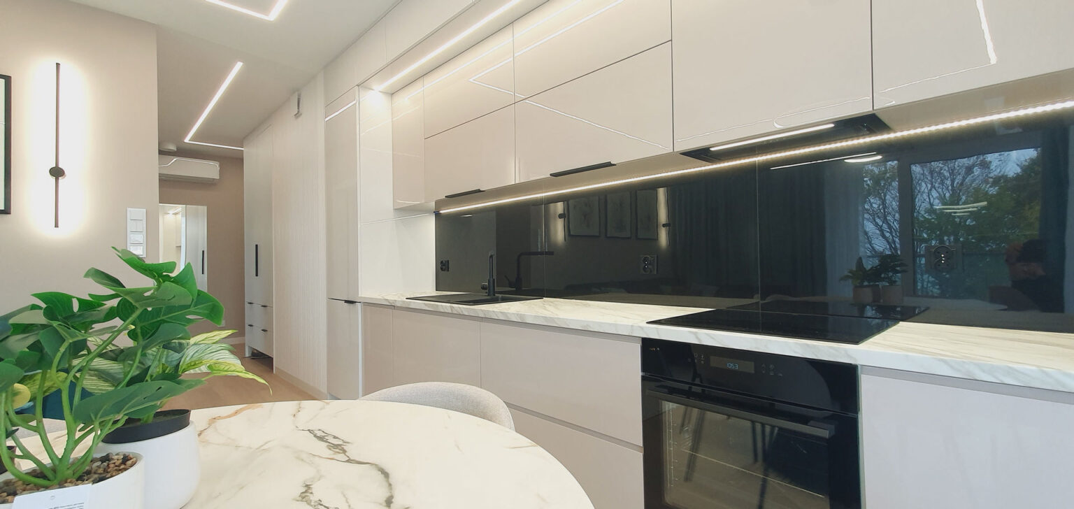 Aneks kuchenny w odcieniach beżu, czarny pas międzyszafkowy