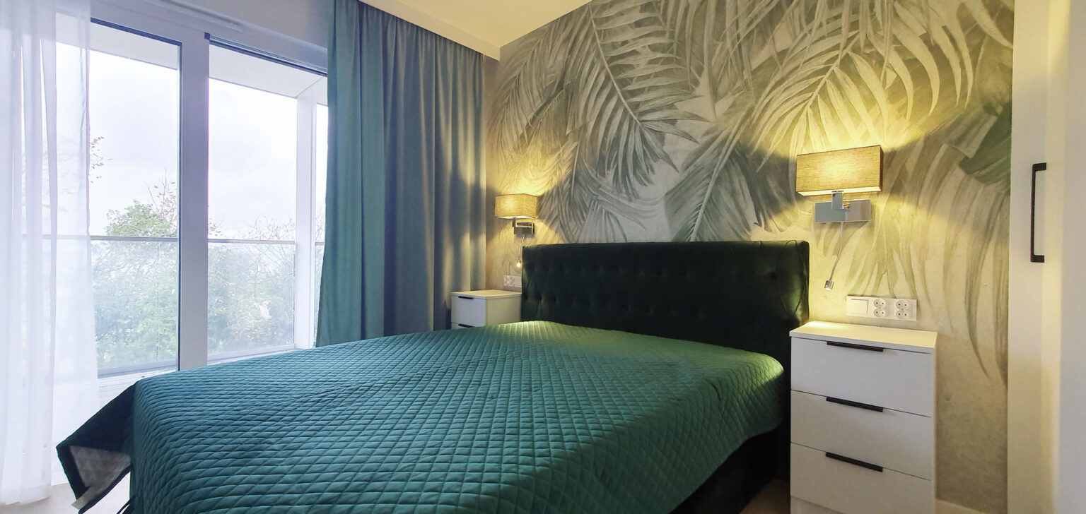 Sypialnia z łóżkiem kontynentalnym i welurowym zagłówkiem