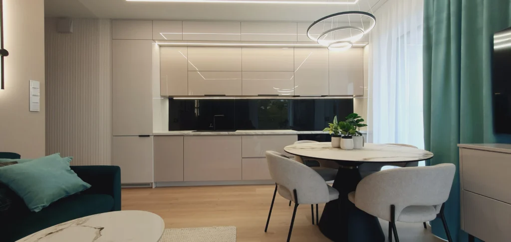Nowoczesna kuchnia z czarnym blatem i okrągłym stołem jadalnianym – apartament wakacyjny w Sianożętach